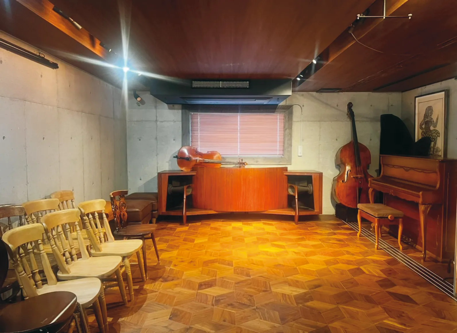 ピアノやコントラバスなどが置かれたサロンの内観の画像