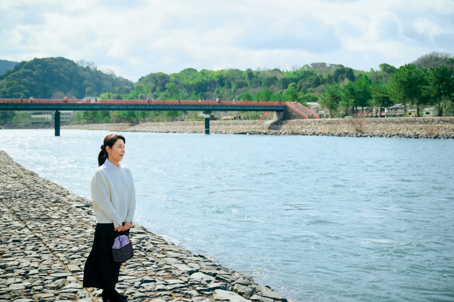 宇治川の川辺に立つ村田範子さんの画像