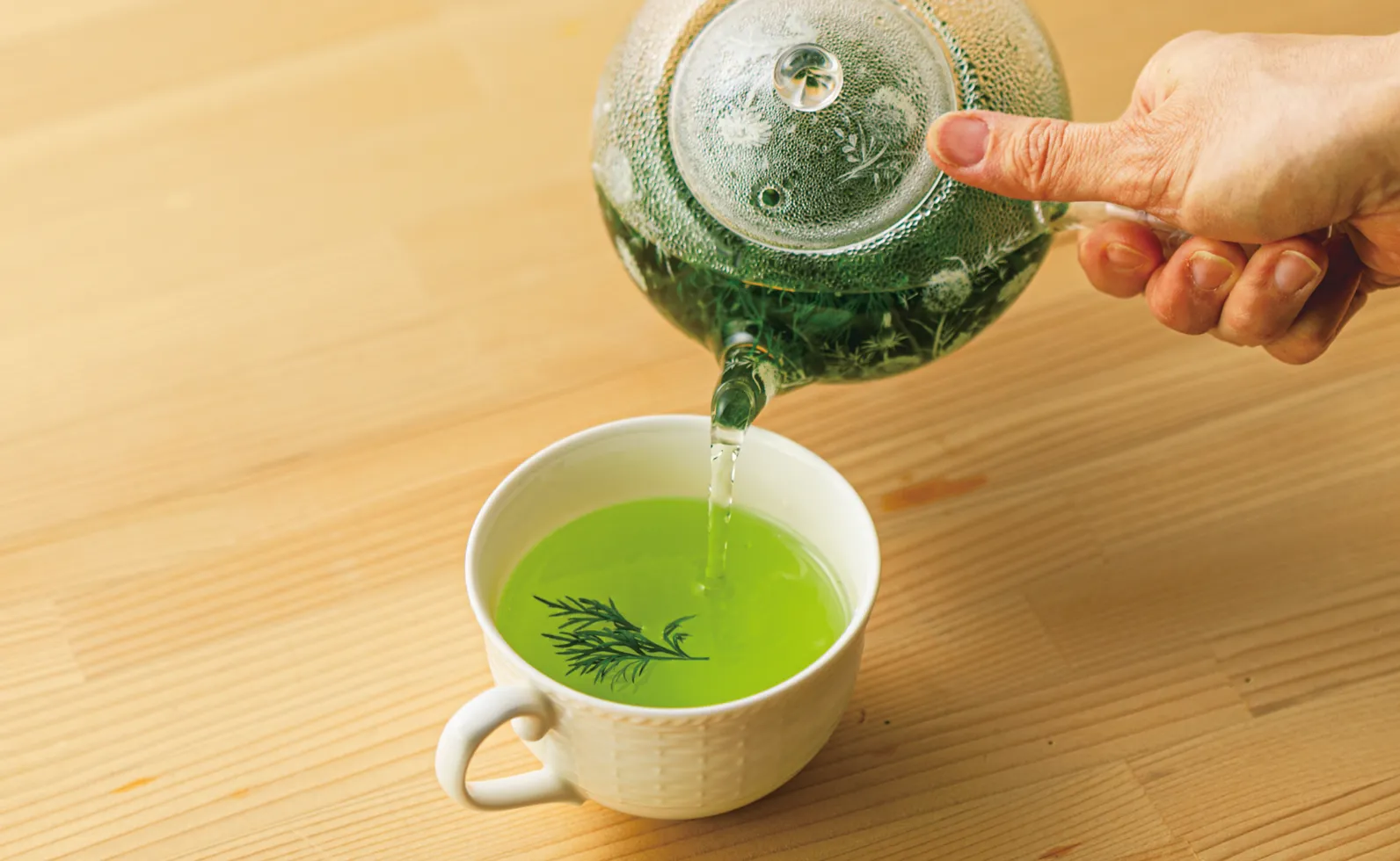 1でハーブを入れたカップに、2のお茶を注いでるところの画像