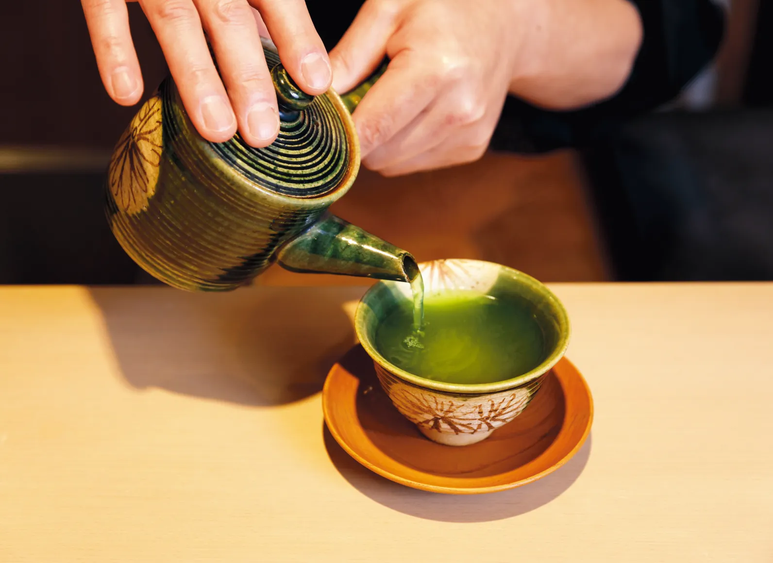 居原田さんが急須で湯呑みにお茶を入れている画像