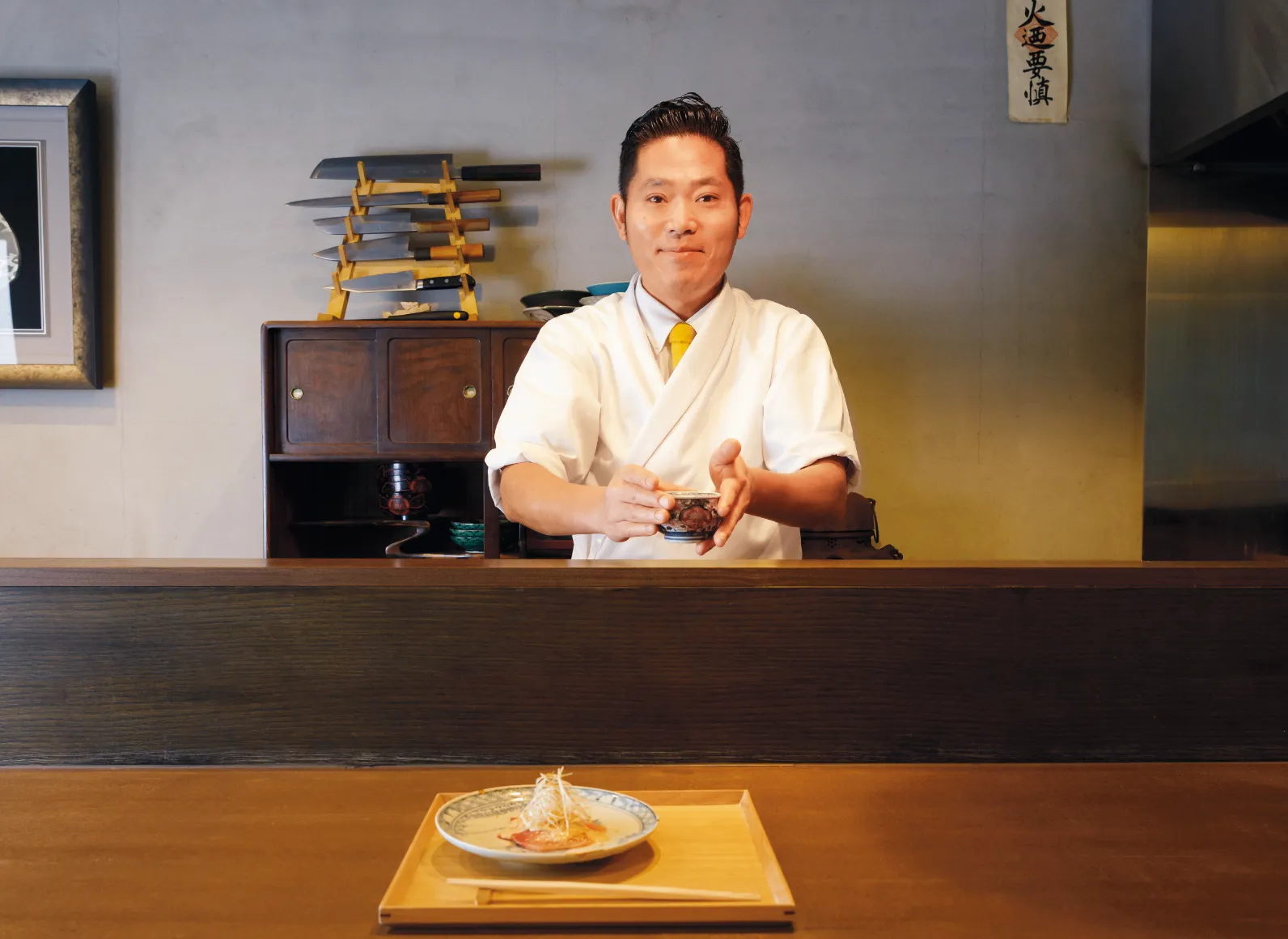 湯呑みを差し出す「六条院拓磨」 店主の森拓磨さんと料理の画像