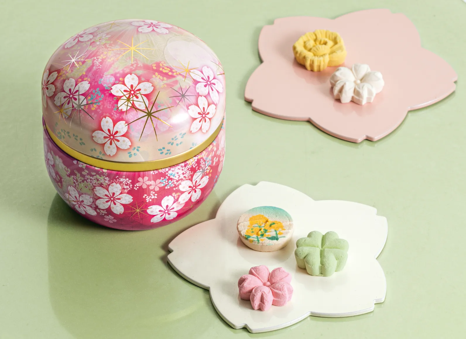 鮮やかな桜色の缶、桜型の皿に並べられた干菓子の画像
