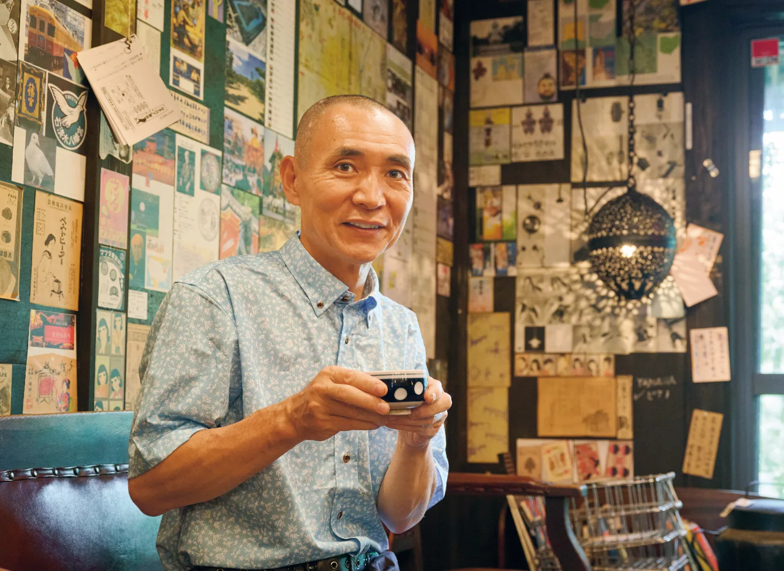 腰掛けてお茶を飲む佐藤さんの画像
