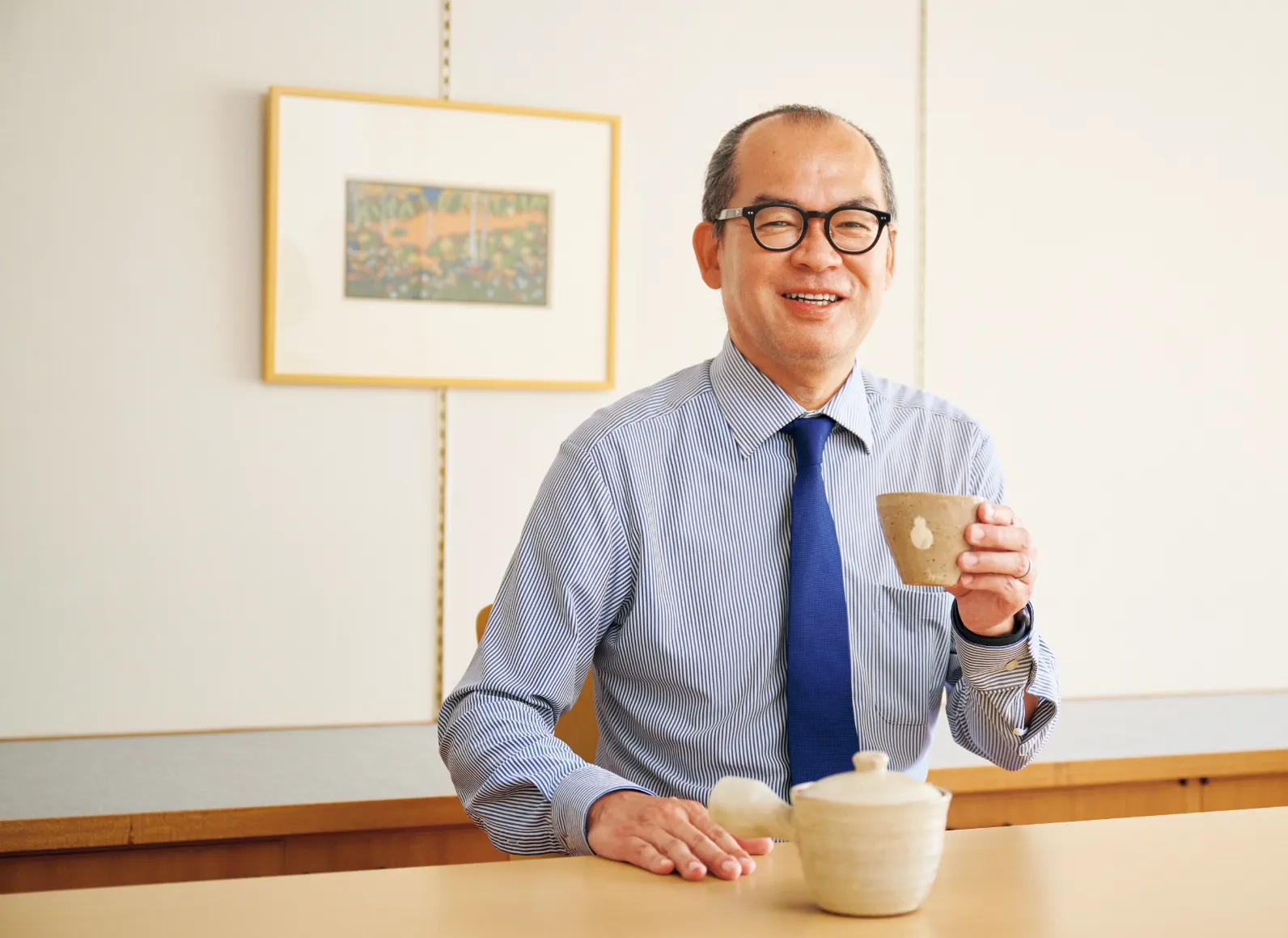 瓢箪6つで「無病」を意味する湯呑を手に持つ井上さんの画像